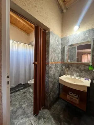 a bathroom with a sink and a toilet at Cabañas aires de montaña in Villa Parque Siquiman