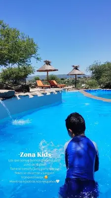 a man in the water at a swimming pool at Cabañas aires de montaña in Villa Parque Siquiman