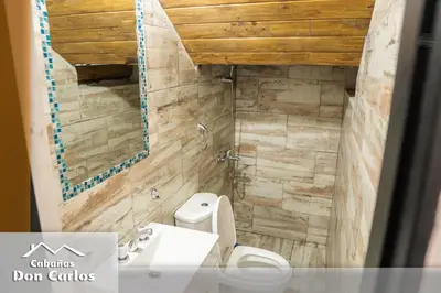 a bathroom with a toilet and a sink at Cabañas Don Carlos in Villa Carlos Paz
