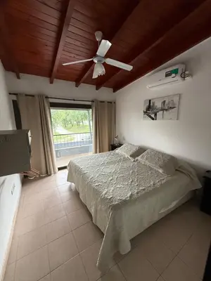 a bedroom with a bed and a ceiling fan at Cabañas Don Carlos in Villa Carlos Paz