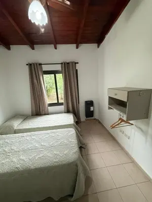 a bedroom with two twin beds and a television at Cabañas Don Carlos in Villa Carlos Paz