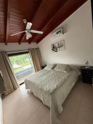 a bedroom with a bed and a ceiling fan at Cabañas Don Carlos in Villa Carlos Paz