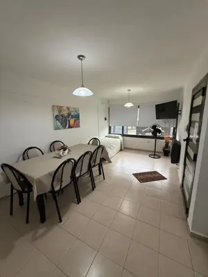 a living room with a table and chairs and a couch at Cabañas Don Carlos in Villa Carlos Paz