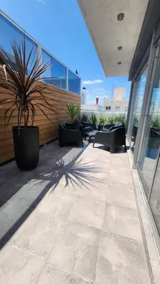 a patio with chairs and a potted plant on a building at Sarmiento deluxe B General Paz Pax 4 in Cordoba