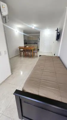 a large bed in a room with a table at Sarmiento deluxe B General Paz Pax 4 in Cordoba