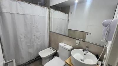 a bathroom with a white toilet and a sink at Sarmiento deluxe B General Paz Pax 4 in Cordoba