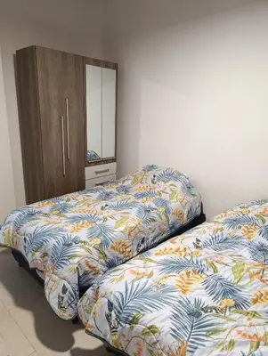 a bedroom with two beds and a dresser and a mirror at Yatel in Santa Rosa de Calamuchita