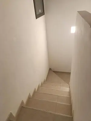 a staircase in a white room with a box on the wall at Yatel in Santa Rosa de Calamuchita