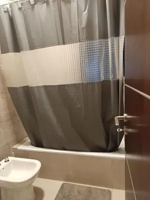 a bathroom with a shower curtain and a toilet at Yatel in Santa Rosa de Calamuchita