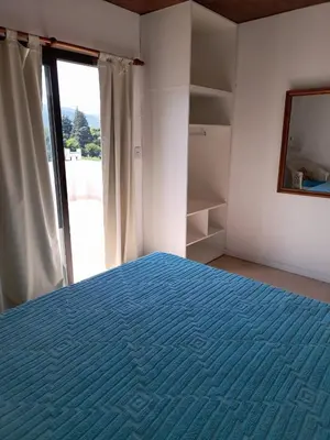 a bedroom with a blue bed and a window at Casa Sol Serrano - con todas las comodidades y excelente ubicación in Villa Carlos Paz