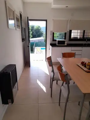 a kitchen and dining room with a table and chairs at Casa Sol Serrano - con todas las comodidades y excelente ubicación in Villa Carlos Paz