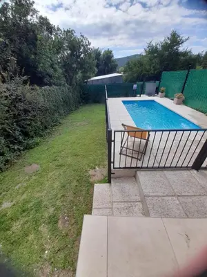 a swimming pool with a bench next to a yard at Casa Sol Serrano - con todas las comodidades y excelente ubicación in Villa Carlos Paz