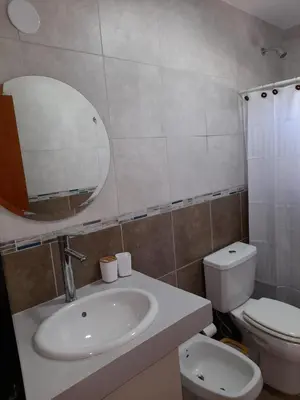a bathroom with a sink and a toilet and a mirror at Casa Sol Serrano - con todas las comodidades y excelente ubicación in Villa Carlos Paz