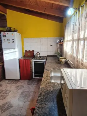 a kitchen with a white refrigerator and a stove at Paseo por las Nubes in Santa Rosa de Calamuchita
