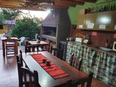 a kitchen with a wooden table with chairs and a stove at Paseo por las Nubes in Santa Rosa de Calamuchita