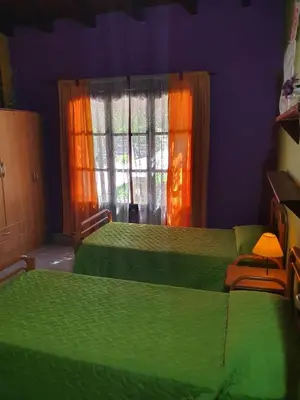 a bedroom with two green beds and a window at Paseo por las Nubes in Santa Rosa de Calamuchita