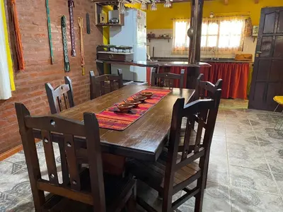 a kitchen with a wooden table and chairs at Paseo por las Nubes in Santa Rosa de Calamuchita