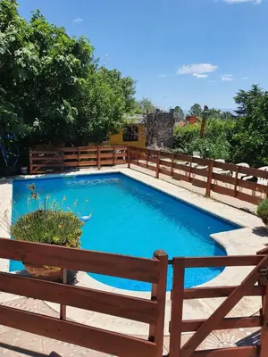 a swimming pool with a wooden fence around it at Paseo por las Nubes in Santa Rosa de Calamuchita