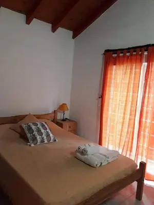 a bedroom with a large bed with a window at Cabañas Cuñas del Trapiche in Trapiche