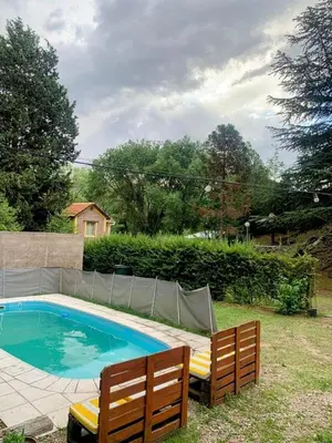 a swimming pool with two wooden benches next to it at Cabañas Cuñas del Trapiche in Trapiche