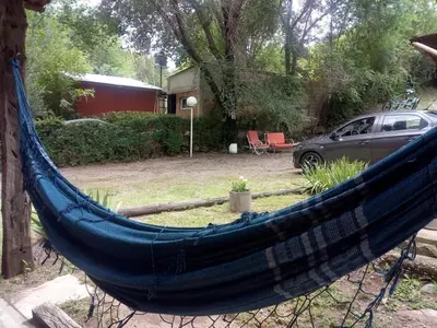 a blue hammock in a yard with a car at Cabañas Cuñas del Trapiche in Trapiche