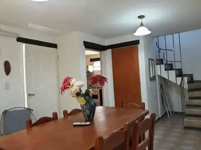 a dining room table with a vase of flowers on it at Cabañas Cuñas del Trapiche in Trapiche