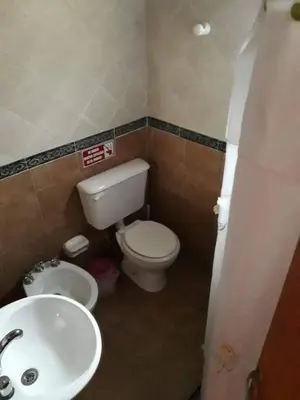 a bathroom with a white toilet and a sink at Cabañas Cuñas del Trapiche in Trapiche