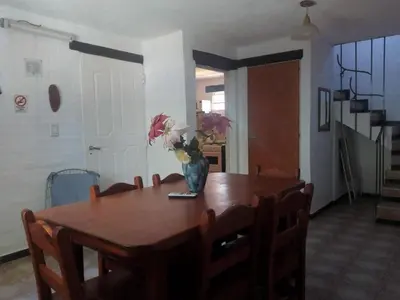 a dining room table with a vase of flowers on it at Cabañas Cuñas del Trapiche in Trapiche