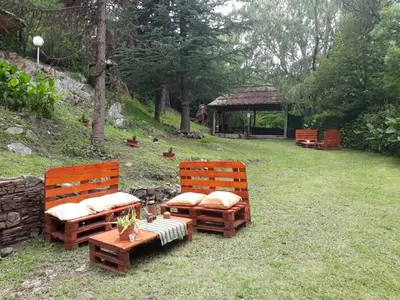 two wooden benches sitting in a yard with a gazebo at Cabañas Cuñas del Trapiche in Trapiche