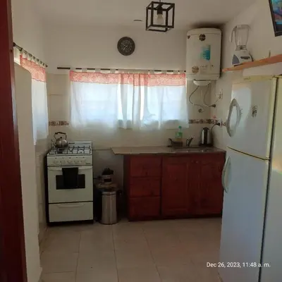 a kitchen with a white stove and a refrigerator at Cabaña del mallin in Bialet Massé