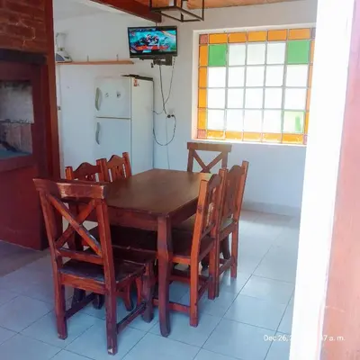 a kitchen with a wooden table and chairs and a refrigerator at Cabaña del mallin in Bialet Massé