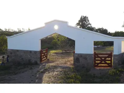 a white building with a gate and a fence at La Casona de Tanti in Tanti