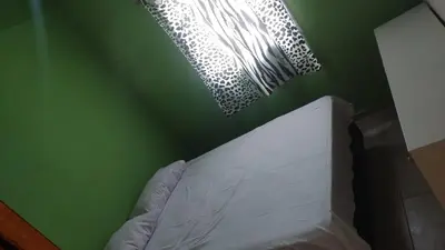 a bedroom with a green wall with a bed and lights at Cabañas Mimi in Villa Anizacate