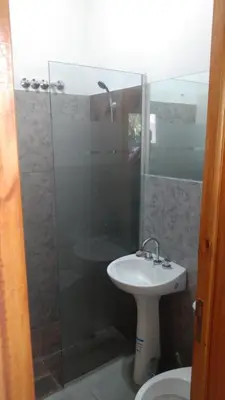 a bathroom with a sink and a glass shower at Cabañas Mimi in Villa Anizacate