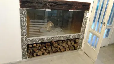 a fire place with logs inside of a room at Cabañas Mimi in Villa Anizacate