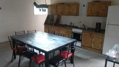 a kitchen with a table and chairs and a refrigerator at Cabañas Mimi in Villa Anizacate