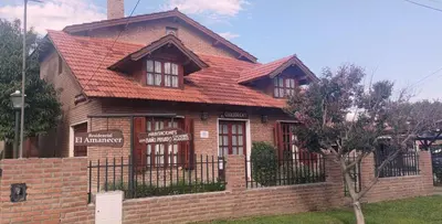 a brown brick house with a red roof at Residencial El Amancer in Mina Clavero