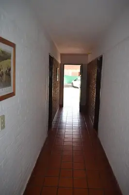 a hallway with a tile floor and a painting on the wall at Residencial El Amancer in Mina Clavero
