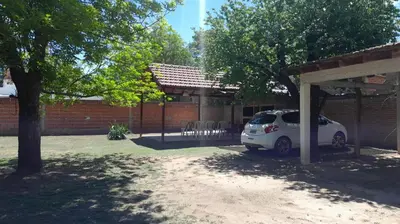 a small car parked under a pavilion in a yard at Residencial El Amancer in Mina Clavero