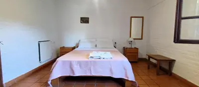 a bedroom with a bed with a pink blanket on it at Residencial El Amancer in Mina Clavero