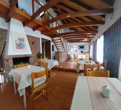 a restaurant with tables and chairs and a fireplace at Residencial El Amancer in Mina Clavero