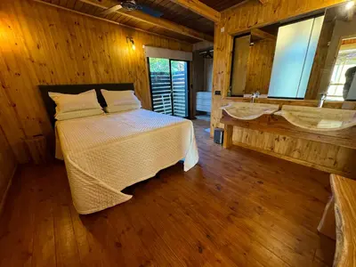a bedroom with a bed and a bathroom with a sink at Cabañas vizcarra in Villa Carlos Paz