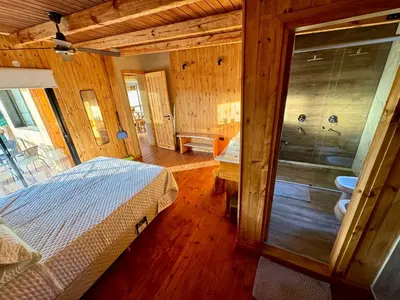 a bedroom with a bed and a bathroom with a shower at Cabañas vizcarra in Villa Carlos Paz
