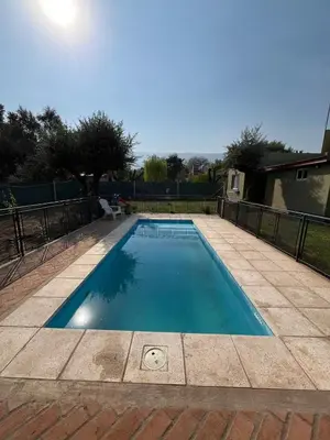 a small swimming pool in a yard with a fence at 