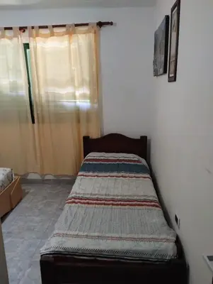 a bed sitting in a corner of a room at Casa La Moradita in Villa Parque Siquiman