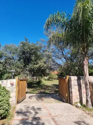 a fence with two wooden gates and a palm tree at Las Veronas in Villa de Las Rosas