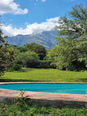 a swimming pool in a field with mountains in the background at Las Veronas in Villa de Las Rosas