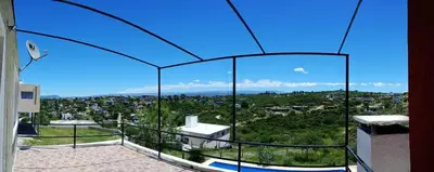a glass house with a view of a city at Casa de vacaciones in Villa Carlos Paz