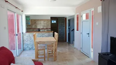 a living room with a table and a kitchen at Casa de vacaciones in Villa Carlos Paz