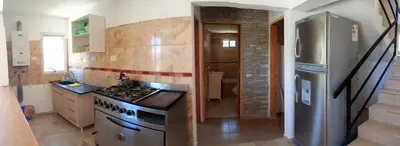 a kitchen with a stove and a refrigerator at Casa de vacaciones in Villa Carlos Paz
